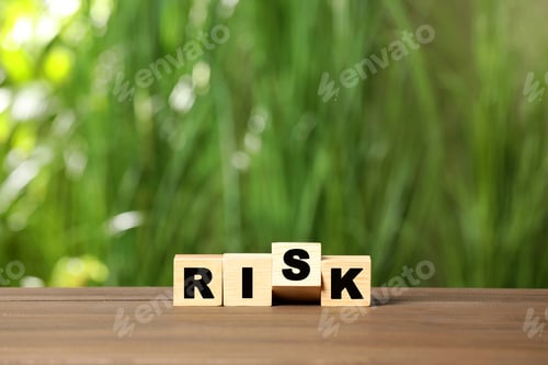 Preview: Cubes with word Risk on wooden table