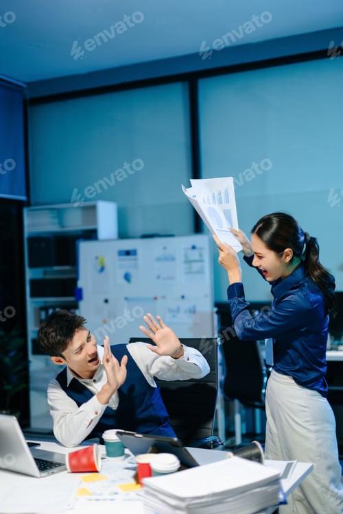 Preview: Asian business colleagues having playful argument in office, showing stress, emotion, and humor