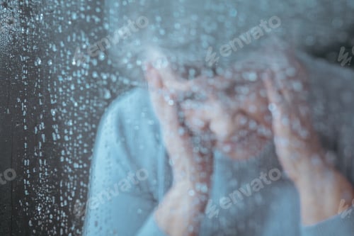 Preview: Sad woman behind the glass