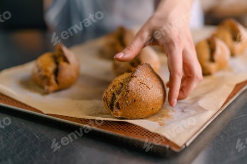 Preview: baker showing hot cut freshly baked crispy and puffy bread bun bakery
