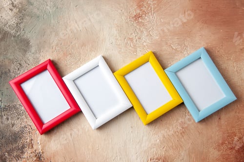 Preview: Above view of four photo frames hung on side by side on mix color wall with free space