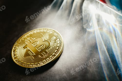 Preview: Bitcoin physical coins illuminated by light rays with dark background.