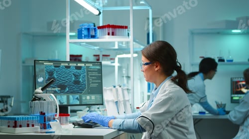 Preview: Scientist nurse typing on pc late at night working in laboratory