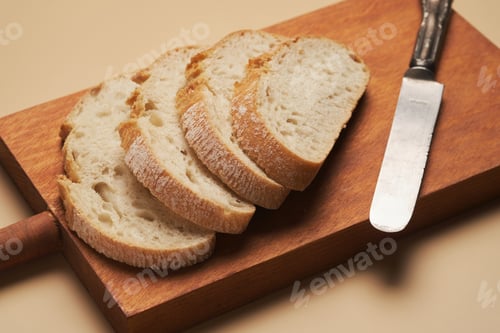 Preview: Freshly Sliced Bread on a Wooden Cutting Board With a Knife Nearby
