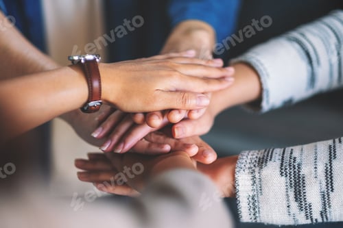 Preview: Closeup image of people putting their hands in stack together