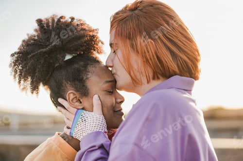 Preview: Lesbian multiracial couple having tender moment at sunset