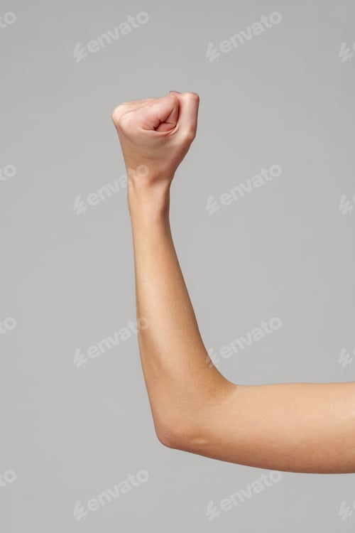 Preview: Female hand with clenched fist on gray background
