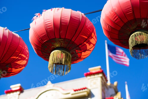 Preview: Low angle shot of Chinese lanterns hanging near an American flag in the background