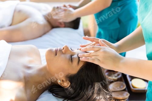 Preview: Massagers Relieving Facial Tension Of Couple At Salon