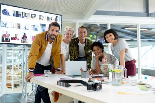 Preview: Front view of diverse business people discussing over laptop in the conference room at office