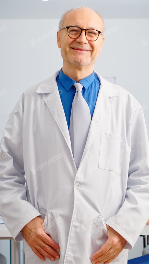Preview: Portrait of elderly man surgeon standing in front of camera smiling