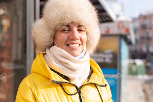 Preview: Woman in winter clothes on a cold day waiting for a bus at a bus stop