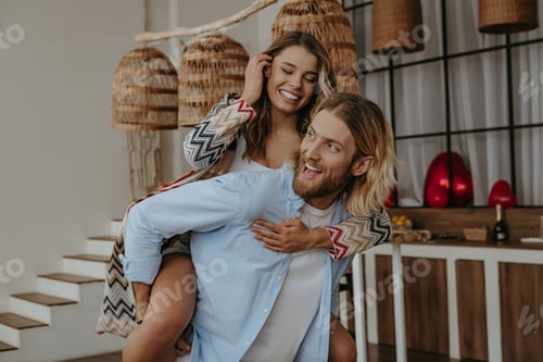 Preview: Smiling Couple Piggyback Ride in Bright Home Interior