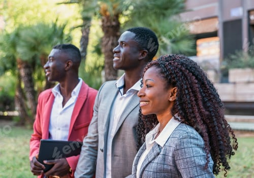 Preview: Three elegant multiracial business people looking up and smiling outdoors, teamwork concept