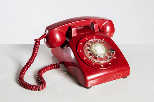 Retro Red Rotary Telephone on a White Surface
