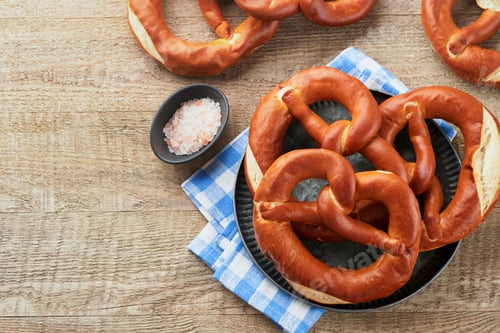 Preview: Oktoberfest concept card. Traditional Bavarian pretzels with beer bottle mug on old rustic wooden ba