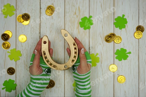 Preview: Women's Hands Hold a golden Horseshoe on St. Patrick's Day