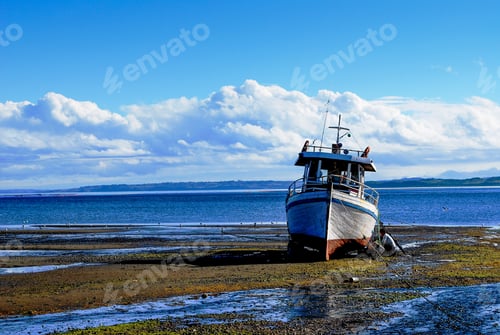 Preview: Picture of a boat on land against water and a mesmerizing clouds