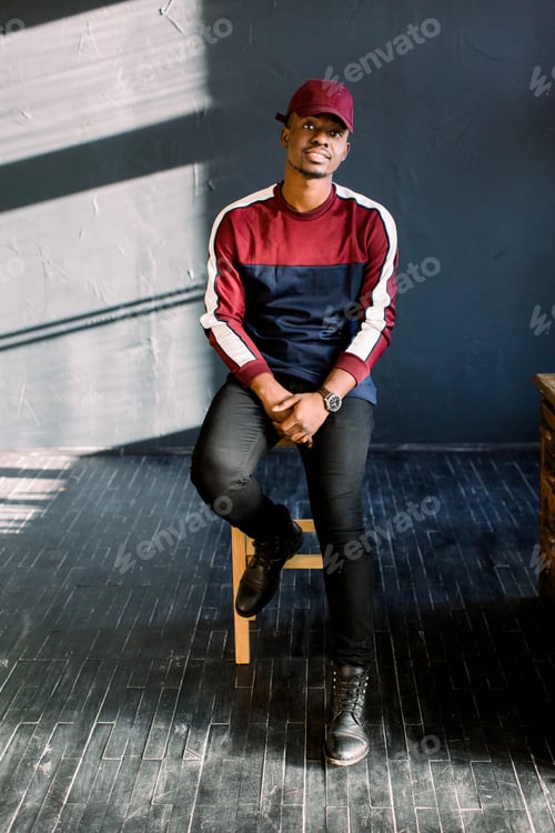 Preview: Portrait of happy young black African guy in red baseball cap