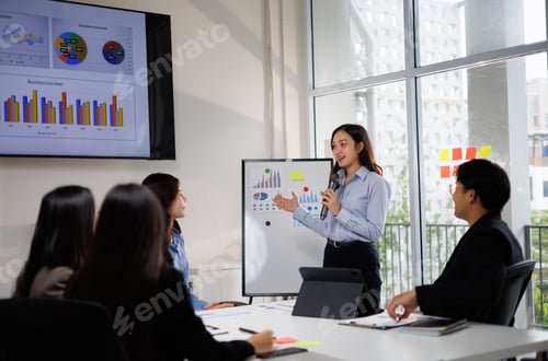 Preview: Asian businesswoman presenting financial data during office meeting