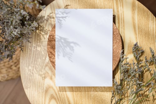 Preview: Mockup paper poster card on round table with grass flower