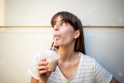 Preview: Close up young woman drinking with straw