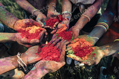 Preview: close-up partial view of young people holding colorful powder in hands at holi festival