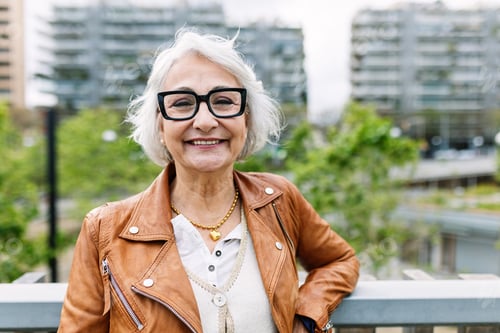 Preview: Cheerful portrait of positive aged woman smiling at camera standing at city