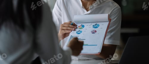 Preview: Close up business people discussing the charts and graphs showing the results of their successful