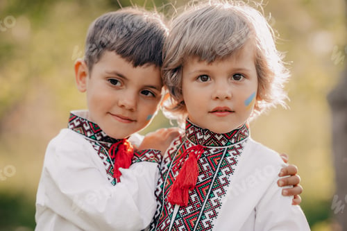 Preview: Smiling little ukrainian boys with blue yellow flag art on cheeks. Children together in traditional