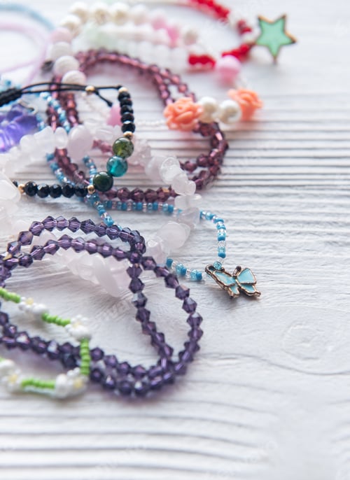 Preview: Colorful handmade beaded bracelets and accessories arranged on a wooden surface