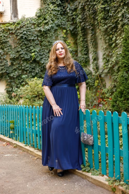 Preview: Woman in a long blue dress in the garden.