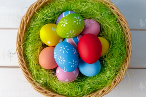 Preview: Colorful eggs placed in a basket with green grass at a celebration event