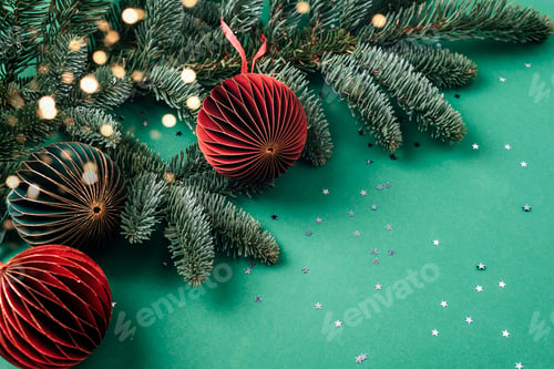 Preview: Paper fir tree toys and branches with golden confetti on green background. Christmas concept.