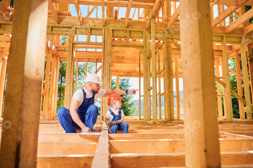 Preview: Father teaching his toddler son the art building wooden frame house on construction site.