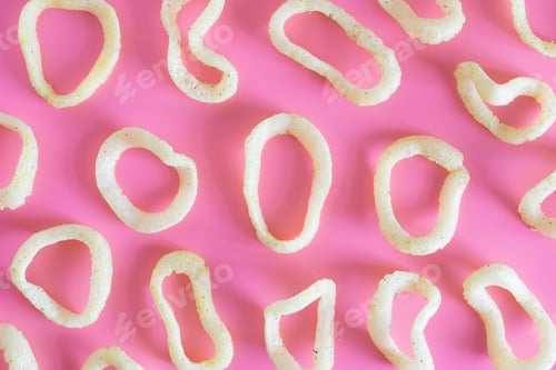 Preview: A bunch of crunchy onion rings close up on a pink background. Snack onion rings.
