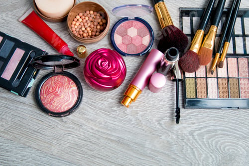 Preview: Set of decorative cosmetics and brushes on grey wooden background. Various makeup products