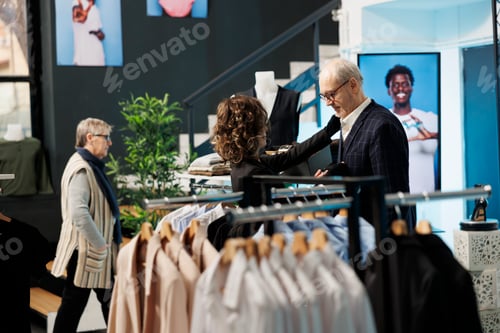 Preview: Boutique worker helping elderly man choosing right tie