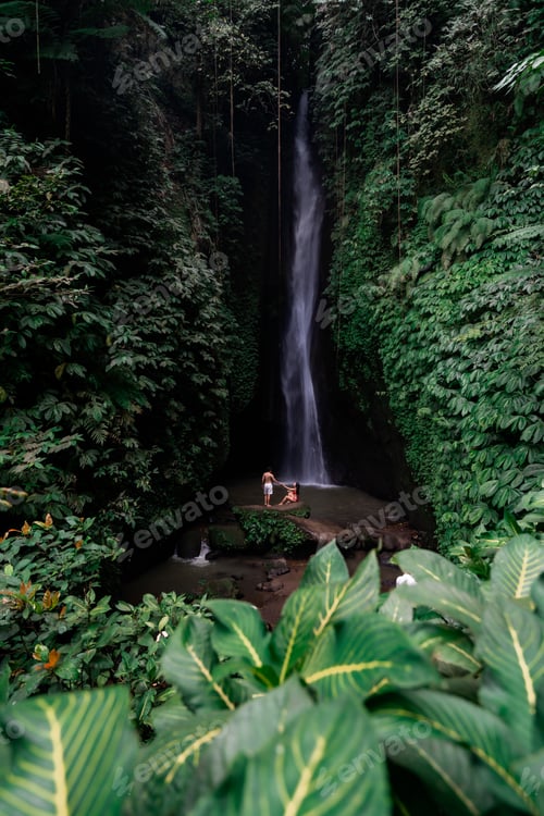Preview: Young couple tourism enjoying the Leke Leke waterfall at Bali in Indonesia