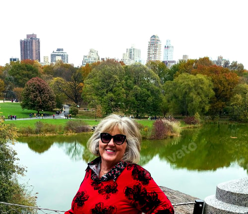 Preview: Active babyboomer in fall fashion standing in the park in front of cityscape of New York skyline...