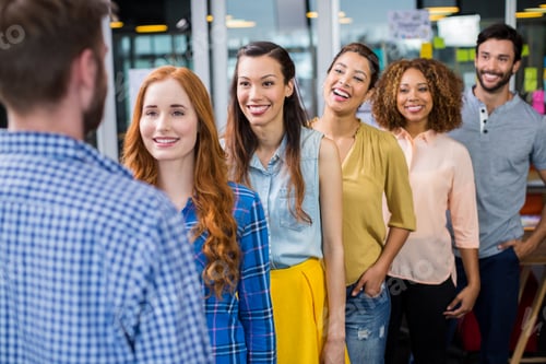 Preview: Smiling colleagues standing in front of male executive