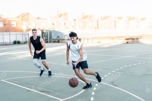 Preview: Two man running while playing basketball in an outdoor court