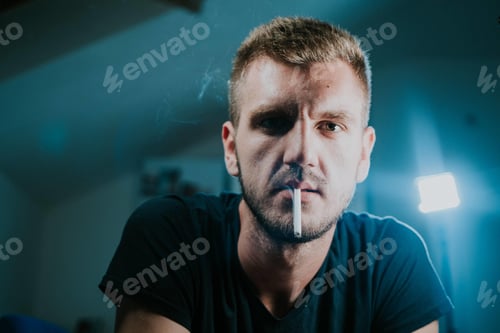 Preview: Portrait of a young blonde male smoking a cigarette