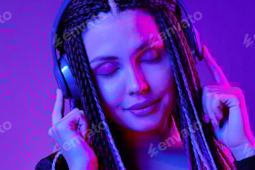 Visualização: Linda mulher com cabelo comprido em tranças ouvindo música com fones de ouvido
