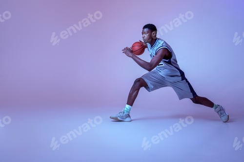Preview: Basketball player practicing with ball in studio
