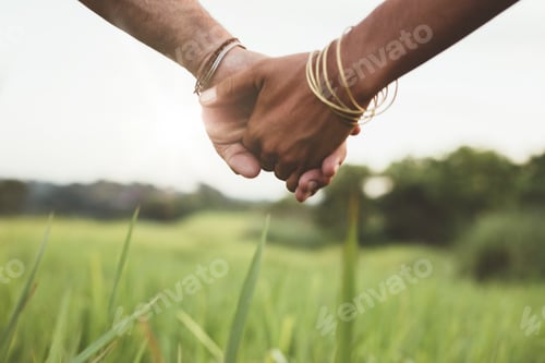 Preview: Young couple holding hands in the field