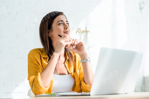 Preview: beautiful thoughtful freelancer working on laptop in home office