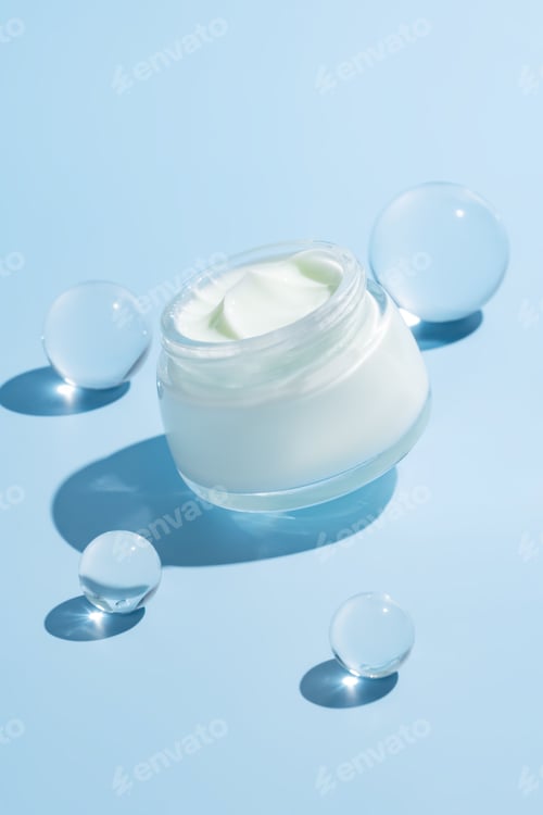 Preview: Open cream jar with glass cooling balls on vibrant blue background. A fresh, luxurious skincare