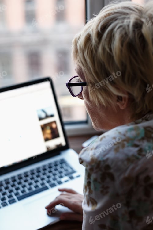 Preview: Back view of woman using laptop