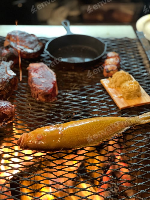 Preview: Fish and steak cooking over an open fire grill
